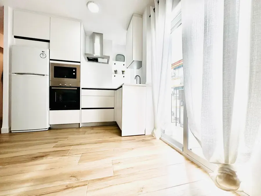 Cocina blanca con horno y microondas en columna